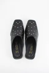 Zueco de cuero color bronce con punta almendrada y detalle de tachas metálicas doradas en toda la capellada. Posee un taco cuadrado bajo de 3 cm.