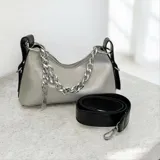 Cartera de mano color plateado con acabado metalizado, diseño estructurado y cierre superior. Presenta una cadena decorativa plateada en el frente y detalles laterales en color negro. Incluye una correa larga ajustable y desmontable en color negro.