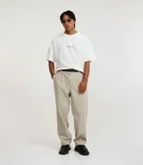 Remera oversized de algodón color blanco, con cuello redondo, manga corta y una estampa trasera en azul de estilo renacentista con la frase "Running from destiny singe antiquity".