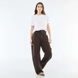 Pantalón de jean color marrón con corte globo, tiro alto y diseño de pierna ancha. Presenta costuras laterales marcadas y cierre frontal con botón y cremallera.