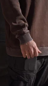 Buzo negro de algodón con cuello redondo y logo bordado en el pecho.