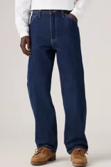Jeans de denim azul oscuro con corte holgado y recto, estilo carpintero, con trabillas para cinturón y bolsillos funcionales.