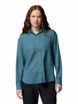 Camisa de senderismo Columbia de manga larga, color azul petróleo, con cuello clásico, cierre frontal con botones y dos bolsillos frontales funcionales. Confeccionada con tecnología de secado rápido y protección solar.