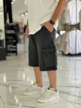 Bermuda de jean estilo cargo con bolsillos laterales con solapa, corte super baggy y lavado efecto desgastado.