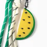 Llavero con mosquetón en forma de corazón, compuesto por cordones de nylon trenzados en colores verde y blanco, y un dije colgante de resina con forma de rodaja de sandía amarilla.
