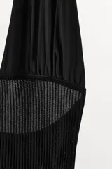 Vestido largo negro de mezcla de viscosa, con cuello halter, escote en pico, hombros descubiertos, tejido acanalado y bajo asimétrico con volados.