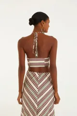 Top de rayas horizontales en tonos crudo, borgoña y verde, con diseño sin tirantes, detalle torcido en el busto y cierre con cordón ajustable.