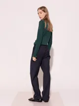 Pantalón de vestir azul marino a rayas verticales blancas, confeccionado en lana sastrera, con cintura sastrera, botas con elástico y tancas para regular.