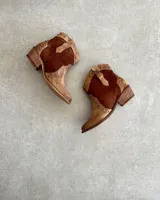 Botas texanas cortas de cuero vacuno color marrón con detalles de cuero marrón oscuro y tachas plateadas.