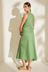 Falda midi verde de lino, con diseño asimétrico, tajito frontal y cierre lateral con botones de madera con ojales bordados.