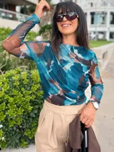 Remera de microtul con estampado abstracto en tonos azules, marrones y beige, de manga larga y cuello redondo.