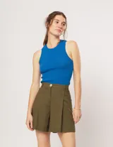 Short verde militar de lino, tiro alto, con elástico en la pretina trasera, cierre delantero y botón. Presenta tablas en el frente, bolsillos delanteros y dobladillo invisible.