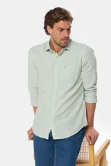 Camisa de manga larga color verde claro, confeccionada en lino, con bolsillo en el pecho, logo bordado y botones personalizados.