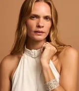 Vestido midi evasé color blanco, confeccionado en viscosa con foil. Presenta cuello halter trenzado, sisa americana y espalda descubierta.