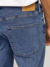 Jean azul de tiro regular, corte tapered y diseño clásico de cinco bolsillos.