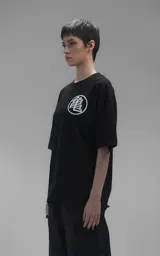 Remera negra de corte oversize con estampa frontal de Goku niño sobre la nube voladora rodeado de esferas del dragón.