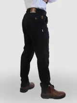 Pantalón de vestir negro, de corte recto, con bolsillos laterales y traseros. Se ajusta a la cintura con cinturón de cuero marrón.