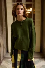 Cardigan tejido de punto color verde con destellos de lurex, cuello redondo, cierre frontal con botones y mangas largas.