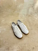 Championes de cuero con estampado animal print en blanco y negro, cordones negros y suela de goma color caramelo.