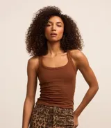 Musculosa básica de calce ajustado confeccionada en tejido de rib con textura acanalada. Presenta escote redondo y breteles medios.