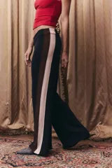 Pantalón tejido de corte recto y holgado, con cintura elástica. Presenta un diseño tricolor en los laterales con franjas verticales en negro, marrón y beige.