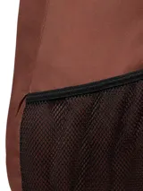 Mochila urbana Caterpillar modelo Tokyo, color marrón, con compartimento principal y bolsillo acolchado para portátil. Cuenta con correas ajustables de malla, dos bolsillos laterales de malla, asa de agarre y detalle reflectante frontal.
