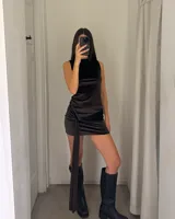 Vestido corto de terciopelo color marrón chocolate, con cuello redondo, sin mangas y detalle de fruncido lateral con caída tipo lazo.