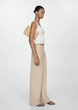 Pantalón de corte recto y diseño fluido, confeccionado en una mezcla de viscosa y poliamida. Presenta un cierre de cremallera invisible en el lateral y un diseño largo.