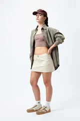 Minifalda color beige estilo cargo, de tiro bajo y corte recto, con bolsillos laterales.