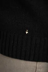 Sweater de punto negro, corte oversize, con cuello redondo y apliques de tachas plateadas en los hombros.