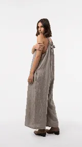 Mono de lino color marrón, de diseño relajado con escote en V pronunciado, breteles anchos, bolsillos laterales y pantalón de pierna amplia.
