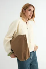 Cartera tipo hobo de gran tamaño, color marrón, con diseño holgado y correa de hombro en cuero sintético color suela.