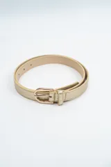 Cinturón fino de textura croco en color dorado, con hebilla metálica clásica en tono dorado.