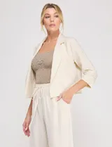 Pantalón holgado de lino color beige de la marca Allie Rose, con tiro alto y pretina elastizada con cordón de ajuste.