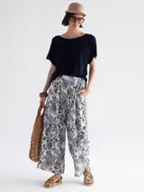 Pantalón palazzo estampado con flores exóticas en tonos azul y blanco.