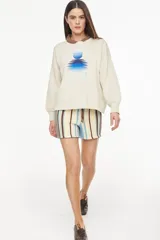 Sweater de punto color amarillo con diseño relajado y escote redondo, confeccionado en mezcla de algodón y acrílico. Presenta un bordado frontal con motivo de sol y reflejos acompañado de la inscripción "Petra".
