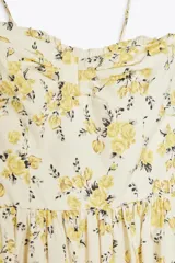 Vestido midi de popelín con estampado floral, escote corazón con volantes y tirantes finos ajustables. Cuenta con bolsillos laterales ocultos, detalle de tablas en el pecho y abertura en la espalda con lazada. Incluye forro interior.