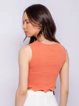 Top color salmón sin mangas, con cuello redondo y terminación ondulada en el ruedo.