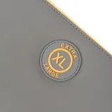 Billetera tipo fichero de color gris con detalles en amarillo, confeccionada en cuero sintético. Presenta un diseño con cierre perimetral, correa de mano desmontable y logo circular de la marca XL Extra Large en el frente. El interior cuenta con múltiples compartimientos para tarjetas y billetes, además de un bolsillo interno con cierre.