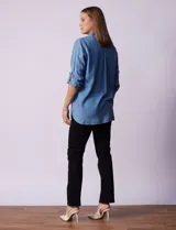 Camisa celeste de tencel con cuello con solapa, abertura central con botones ocultos, bolsillos delanteros y mangas largas regulables con presilla y botón.