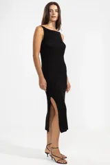 Vestido largo negro tejido en jersey con hilo lurex plateado, escote bote y corte con abertura lateral.