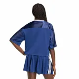 Remera de mujer Adidas W Sta Seas Tee, de color azul marino con diseño estilo jersey deportivo, cuello en V y mangas cortas con las clásicas franjas de la marca. Presenta el logotipo y la inscripción de Adidas estampados en el frente.