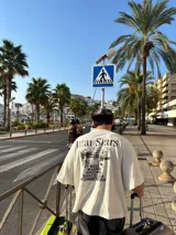 Remera marrón de corte holgado con estampado en la espalda que incluye texto y paisaje.