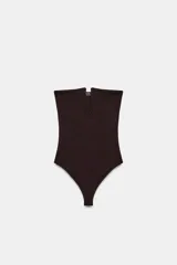 Body de tejido elástico color marrón oscuro, con diseño strapless, escote recto con abertura frontal y cierre inferior con botones a presión.