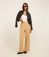 Pantalón wide leg de sastrería color beige, con tiro alto, cierre tradicional y doble botón en la cintura.