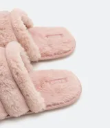 Pantufla cerrada de diseño acolchado con gajos, confeccionada en tejido de textura felpuda suave, con suela de goma termoplástica.
