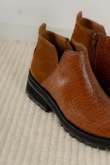 Botinetas de cuero color marrón con paneles laterales de gamuza en tono más oscuro y suela track negra de goma.