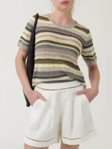 Remera RKF modelo Lite de algodón orgánico, con diseño de rayas horizontales en tonos beige, verde, amarillo y gris, cuello redondo y mangas cortas. Presenta detalles calados y terminaciones con ondas en cuello, mangas y ruedo.