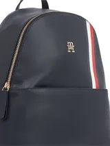 Mochila Tommy Hilfiger de diseño compacto en color azul marino. Presenta una franja vertical tricolor característica de la marca, logo TH metalizado en la parte frontal, asa superior y cierre principal con cremallera.