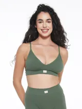 Top deportivo de estilo bralette, confeccionado en tejido seamless acanalado de color verde militar. Presenta escote en V, breteles finos y una banda elástica inferior con una pequeña etiqueta decorativa central.